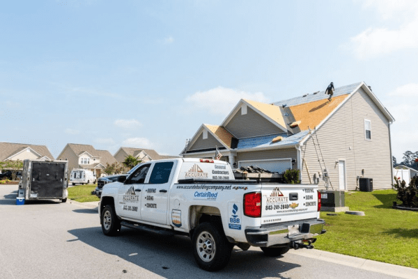 image shows Accurate Building truck on site of a roof installation in Myrtle Beach SC